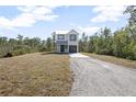 Two-story house with gray metal roof and gray garage door, sits on a grassy lot at 765 6Th Ave, Osteen, FL 32764