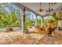 Relaxing patio with pool view, stone pavers, and unique wooden furniture at 14502 Scotch Pine Ct, Orlando, FL 32832