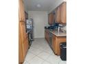 Bright kitchen featuring wood cabinets, stainless steel dishwasher, and tile floors at 2902 Calumet Dr, Orlando, FL 32810