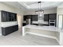 Modern kitchen with dark cabinetry, quartz countertops, and stainless steel appliances at 547 Sanctuary Golf Pl, Apopka, FL 32712
