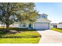 Two-story house with white exterior, blue accents, and a two-car garage at 608 Bluebill Ct, Kissimmee, FL 34759