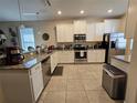 Open concept kitchen with granite countertops and stainless steel appliances at 9037 Shadow Mountain St, Davenport, FL 33896