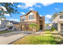 Two-story house with a tan exterior, attached garage, and landscaping at 15321 Beamleigh Rd, Winter Garden, FL 34787