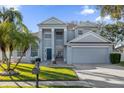 Two-story house with gray siding, a three-car garage, and a manicured lawn at 1813 Sugar Cove Ct, Ocoee, FL 34761