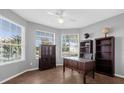 Bright home office with built-in shelves, a desk, and large windows at 1813 Sugar Cove Ct, Ocoee, FL 34761