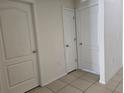 Interior hallway with white doors and tiled floors at 1884 Hickory Bluff Rd, Kissimmee, FL 34744