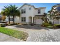 Two-story house with a white exterior, two palm trees, and a brick driveway at 4738 Sleepy Hollow Dr, Kissimmee, FL 34746