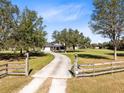 Long driveway leading to a charming two-story home with a large front yard at 10901 Island Grove Rd, Clermont, FL 34711