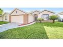 Curb appeal abounds with this one-story house, attached garage, and neatly kept lawn at 163 Jaybee Ave, Davenport, FL 33897