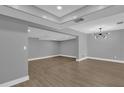 Spacious living room with gray walls, wood floors, and a modern chandelier at 3553 Greenfield Ave, Orlando, FL 32808