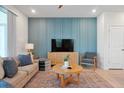 Living room features a blue accent wall, comfy seating, and a large TV at 866 Paradise Dr, Davenport, FL 33897