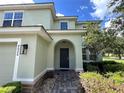 Front entryway with arched entry, stone accents, and landscaping at 9026 Paolos Pl, Kissimmee, FL 34747