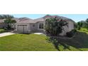 One-story home showcasing a side view with lush landscaping at 27000 Nature View St, Leesburg, FL 34748