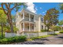 Two-story house with balcony, white columns, and a white picket fence at 4685 Anson Ln, Orlando, FL 32814