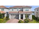 Two-story house with gray siding, brown tile roof, and a two-car garage at 13333 Oakenshaw Ln, Orlando, FL 32832