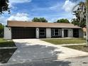 Updated one-story house featuring a dark brown garage door and gray accents at 7023 Talbot Dr, Orlando, FL 32819