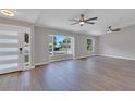 Spacious living area showcasing hardwood floors, large windows, and ceiling fans at 7023 Talbot Dr, Orlando, FL 32819