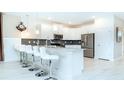 Modern kitchen with white cabinets, gray backsplash, and breakfast bar at 8823 Interlocking Ct, Davenport, FL 33896