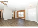 Dining area with wood-paneled walls and vinyl flooring, view of kitchen at 165 Moss Dr, Debary, FL 32713