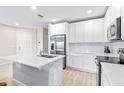 Modern kitchen with white cabinets, stainless steel appliances, and quartz countertops at 4701 New Orleans Cv, Oviedo, FL 32765