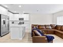 Open concept living area with brown leather sectional sofa and kitchen island view at 4701 New Orleans Cv, Oviedo, FL 32765