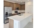 Modern kitchen featuring a large island with white countertops and stainless steel appliances at 6116 Success Way, St Cloud, FL 34771
