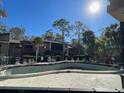Community pool area with surrounding lounge chairs at 5466 Pine Creek Dr # 2002, Orlando, FL 32811