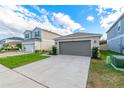 One-story house with gray garage door and landscaped front yard at 591 Preserve Pointe Blvd, Davenport, FL 33837