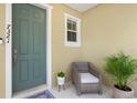 Inviting entryway with teal door, wicker chair, and potted plants at 7321 Brightland St, Windermere, FL 34786