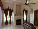 Cozy Gathering room with a fireplace and built-in shelving at 9111 Woodbridge Oak Ter, Orlando, FL 32825