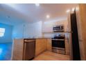 Open concept kitchen with stainless steel appliances and light wood cabinets at 1210 Southstation Pl # 303, Orlando, FL 32809