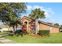 Attractive home with palm trees, lush landscaping, and a two-car garage at 167 Castaway Beach Way, Kissimmee, FL 34746