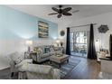Living room with gray couch, patterned armchairs, and access to a balcony at 608 Gran Bahama Blvd # 608, Davenport, FL 33897