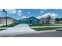Newly constructed teal home with a two-car garage and well-manicured lawn at 1963 Turtle Dove Ln, Kissimmee, FL 34746