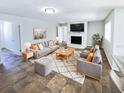 Spacious living room with a stone fireplace, tiled floors, and comfortable seating at 4026 Tenita Dr, Winter Park, FL 32792