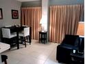 Living room features a black couch and a dining table at 6165 Carrier Dr # 2103, Orlando, FL 32819