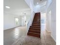 Two-story foyer with a wooden staircase and tiled floors at 1137 Osprey Way, Apopka, FL 32712