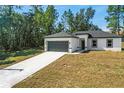 Newly built home featuring a gray garage door and a long driveway at 16921 Sw 25Th Ct, Ocala, FL 34473