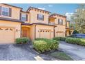 Tan townhome with attached garage, landscaping, and a paved driveway at 2020 Retreat View Cir, Sanford, FL 32771