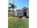 One-story house with a two-car garage and palm trees in the front yard at 10198 Oak Crest Rd, Orlando, FL 32829