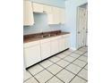 White cabinets, double sink, and tile floor in this kitchen at 1096 E Lombardy Dr, Deltona, FL 32725