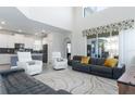 Open living room with high ceilings, a large sectional sofa, and a view of the pool at 1593 Mulligan Blvd, Davenport, FL 33896