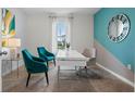 Home office with teal and gray accent walls, a white desk, and two teal armchairs at 308 Corso Loop, Winter Haven, FL 33884
