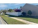 Landscaped side yard with white vinyl fence at 553 Whittingham Pl, Lake Mary, FL 32746