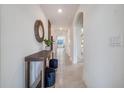 Bright entryway with a console table, mirror, and two blue velvet ottomans at 7140 Painted Bunting Way, Saint Cloud, FL 34773