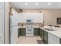 Modern kitchen with white and green cabinets and stainless steel appliances at 108 Paradise Parade # 23, Davenport, FL 33897