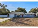 Newly renovated home with gray exterior, red door, and a long driveway at 27623 Lisa Dr, Tavares, FL 32778