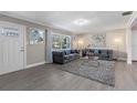 Spacious living room featuring gray sofas, a coffee table, and stylish decor at 27623 Lisa Dr, Tavares, FL 32778