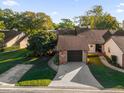 Aerial view of a condo with a one car garage and mature landscaping at 175 Golf Club Dr # 175, Longwood, FL 32779