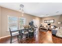 Open concept living and dining area with hardwood floors, gray furniture and a large dining table at 3212 Cupid Pl, Kissimmee, FL 34747
